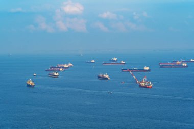 Kargo tanker taşımacılığı kavramında gemi. Mavi gökyüzü ile Singapur limanından tekne öğle saatlerinde nakliye. Açık mavi deniz.