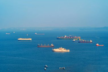 Kargo tanker taşımacılığı kavramında gemi. Mavi gökyüzü ile Singapur limanından tekne öğle saatlerinde nakliye. Açık mavi deniz.