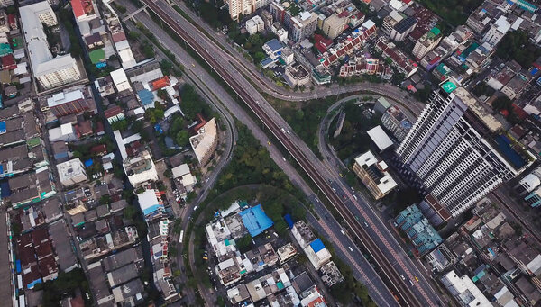 Aerial view of cars on Taksin Bridge in financial district and skyscraper buildings in transportation concept. Top view of urban city, Bangkok. Downtown area, Thailand.