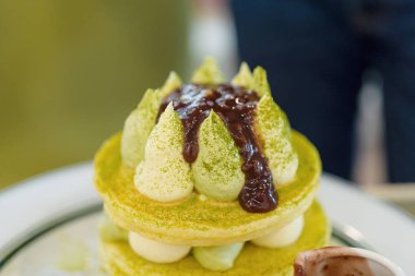 Yeşil çay, şurup ve izole çilek ile yığın gözleme. Sağlıklı kahvaltı