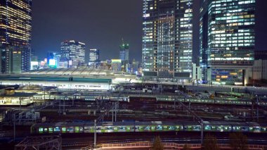 Trenler Tokyo Tren İstasyonu ile yüksek binaların içinde. Şehir Merkezi ve finans bölgesine ve iş merkezleri gece, Tokyo akıllı kentsel şehir içinde Japonya