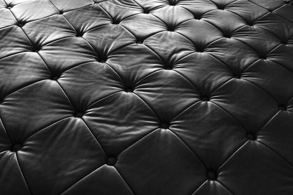 black leather sofa, pattern surface texture. Close-up of interior material for design decoration background