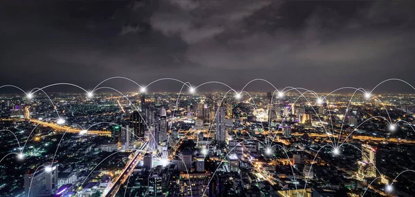 Digital network connection lines of Sathorn, Bangkok Downtown, Thailand. Financial district and business centers in smart urban city in Asia. Skyscraper and high-rise buildings at night.