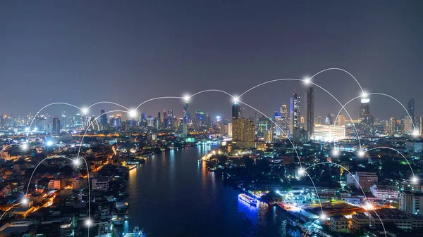 Digital network connection lines of Sathorn with Chao Phraya river, Bangkok Downtown, Thailand. Financial district and business center in smart technology urban city. Skyscraper and buildings at night