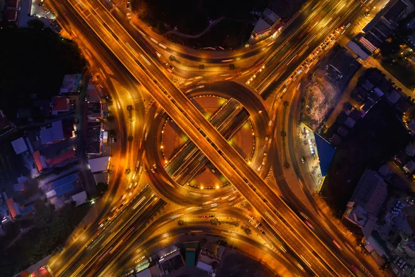 Aerial view of highway junctions with roundabout. Bridge roads shape circle in structure of architecture and transportation concept. Top view. Urban city, Bangkok at night, Thailand.