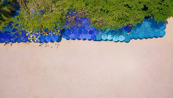 Letecký pohled na barevné deštníky, pláž a tyrkysové moře s — Stock fotografie