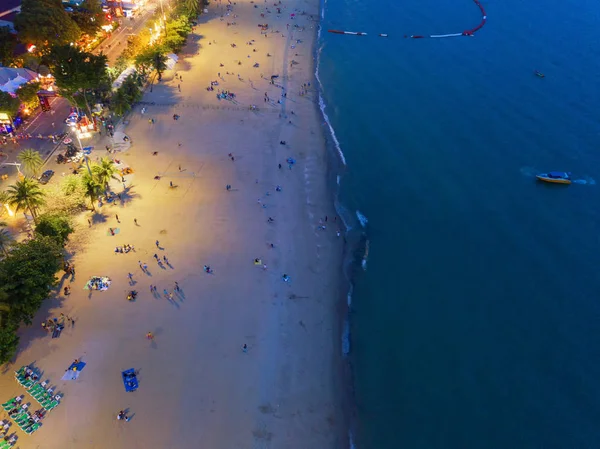 Aerial view of boats in Pattaya sea, beach at night, and urban c