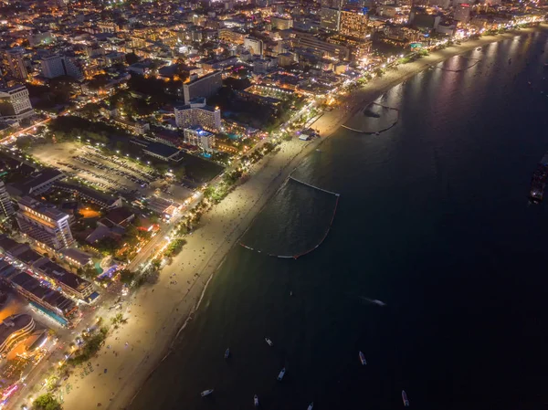 Aerial view of boats in Pattaya sea, beach at night, and urban c