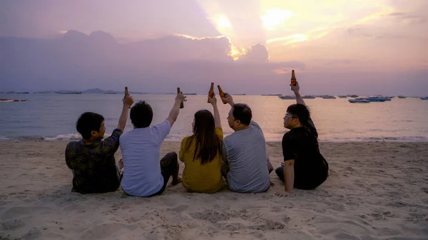 Gruppe thailändischer Leute, asiatische Freunde, klimpernde Bierflaschen zu — Stockfoto
