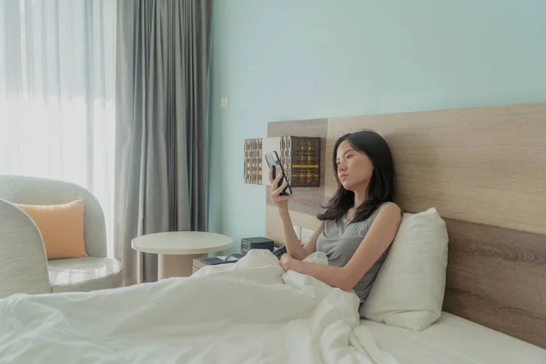 Mulher asiática usando um telefone celular, pensando em problemas e su — Fotografia de Stock