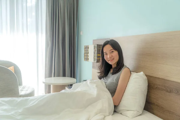 Ritratto di donna asiatica carina che guarda la macchina fotografica sul letto in un moderno — Foto Stock