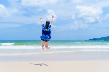 Mutlu Asyalı kadın atlama, rahatlatıcı ve plaj du zevk