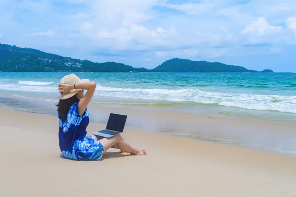 Szczęśliwy Asian kobieta przy użyciu laptopa komputerowego na plaży podczas TR — Zdjęcie stockowe