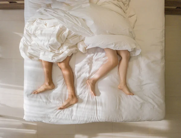浪漫情侣睡觉的顶视图。光脚的腿 — 图库照片
