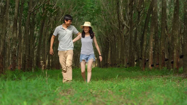 Happy Asian couple traveling at tree tunnel, jungle forest in ru