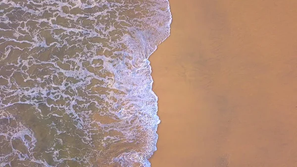 Luchtfoto van het strand met golven die in de kust rollen met kopie — Stockfoto