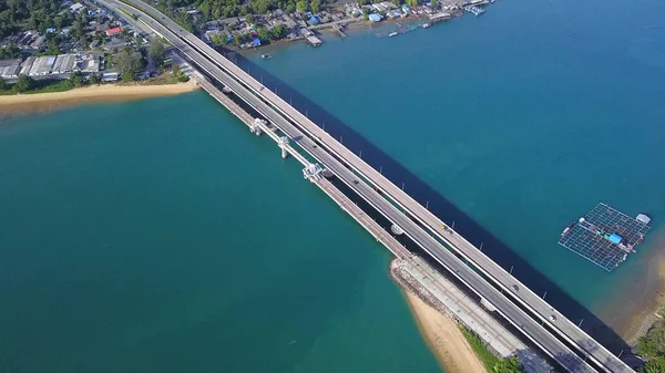 Luftaufnahme von Auto fahren auf einer Brücke mit natürlichen Waldbäumen, Sand, tropischem Strand und Wellen, die ins Ufer rollen, andaman sea, phuket bay island in summer season, Thailand. Ansicht von oben — Stockfoto