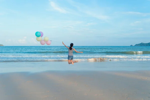 快乐的亚洲女人在沙滩上拿着五颜六色的气球 — 图库照片