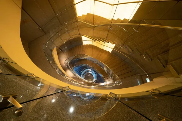 Luxury spiral staircase in lobby hotel with marble floor. Lighti