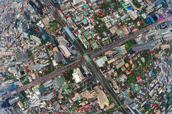 Aerial view of Sathorn intersection or junction with cars traffic, Bangkok Downtown. Thailand. Financial district and business centers in smart urban city. Skyscraper and high-rise buildings.