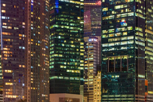 Padrão de edifícios de escritórios janelas iluminadas à noite. Lighti. — Fotografia de Stock
