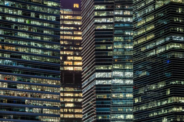 Padrão de edifícios de escritórios janelas iluminadas à noite. Lighti. — Fotografia de Stock