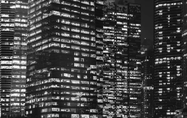 Padrão de edifícios de escritórios janelas iluminadas à noite. Lighti. — Fotografia de Stock