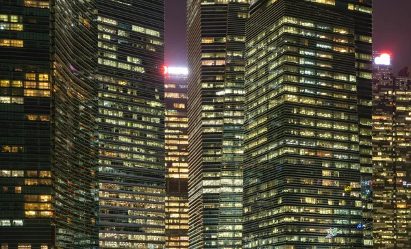 Padrão de edifícios de escritórios janelas iluminadas à noite. Lighti. — Fotografia de Stock