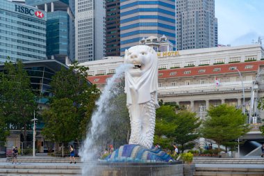 Merlion öğlen Singapur City gökdelen binaları ile. Yüzgeç