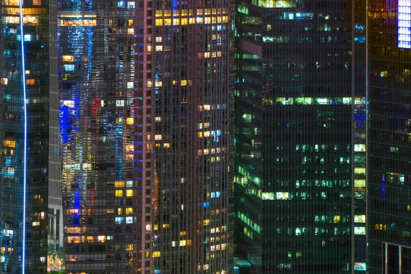 Pattern of office buildings windows illuminated at night. Lighti