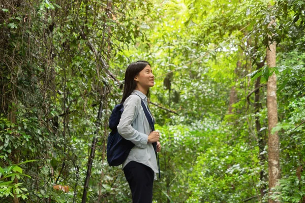 Boldog ázsiai nő pihentető és élvezi a trópusi erdőben w — Stock Fotó