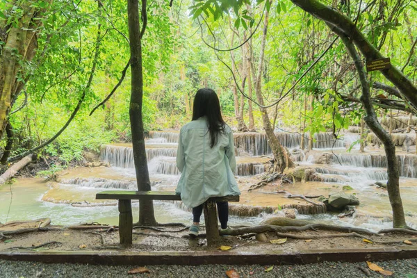 Mulher asiática feliz relaxar e desfrutar na cachoeira com árvores — Fotografia de Stock