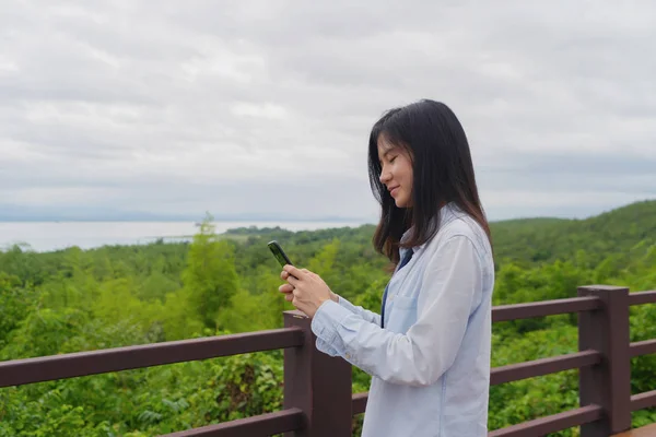 Glückliche asiatische Frau mit dem Handy chatten oder Freund anrufen — Stockfoto