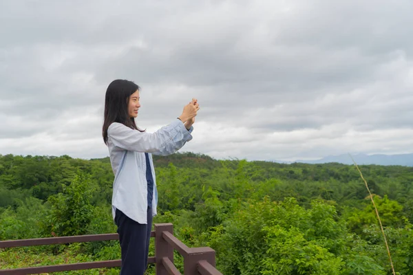 Šťastná žena používá mobil, aby fotografovala s kamerou o — Stock fotografie