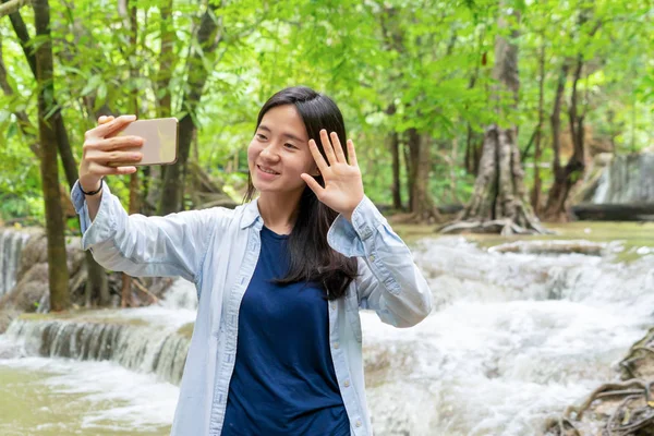 Lycklig asiatisk kvinna tar en selfie att posta på sociala medier på Wat — Stockfoto
