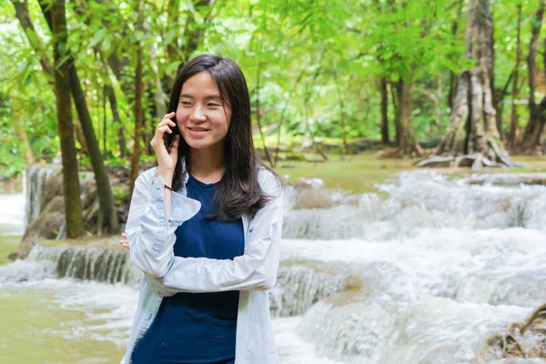 Mulher asiática feliz usando smartphone móvel para conversar ou chamar amigo — Fotografia de Stock