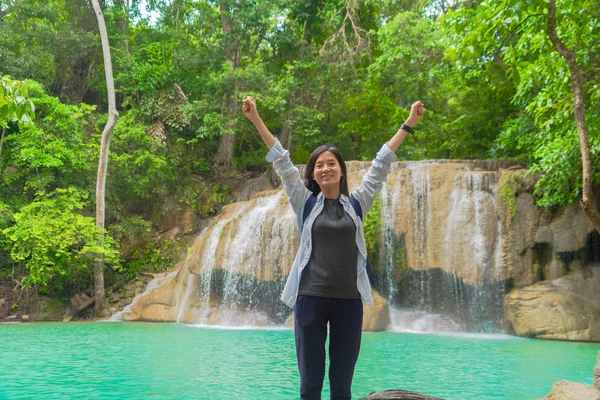 Mulher asiática feliz relaxar e desfrutar na cachoeira Erawan com — Fotografia de Stock