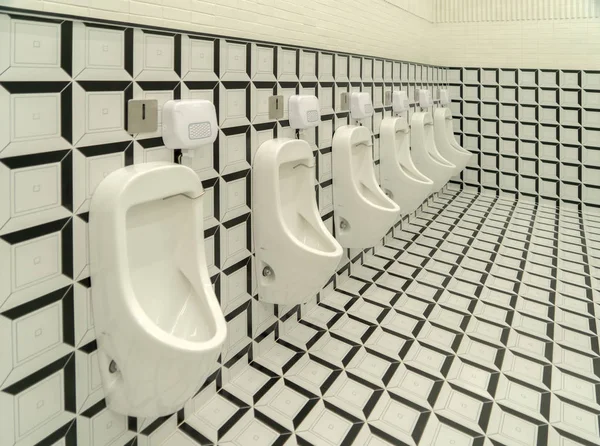 Rangée d'urinoirs modernes noirs et blancs hommes toilettes publiques checker — Photo