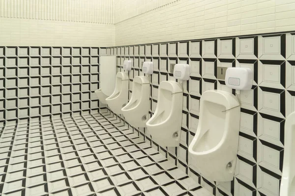 Fila de urinarios modernos en blanco y negro hombres damero de baño público — Foto de Stock