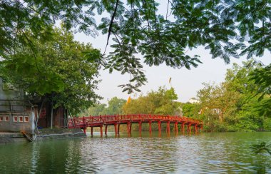 Halk parkındaki ağaçlı ve yansımalı Kızıl Köprü.