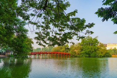 Halk parkındaki ağaçlı ve yansımalı Kızıl Köprü.