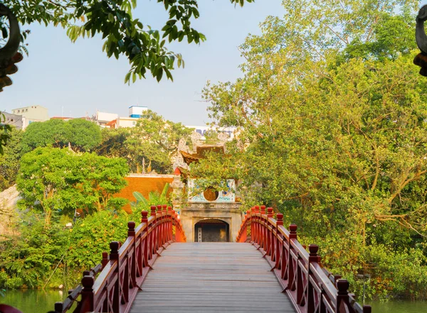 Le pont rouge dans le jardin du parc public avec des arbres et des reflets i — Photo