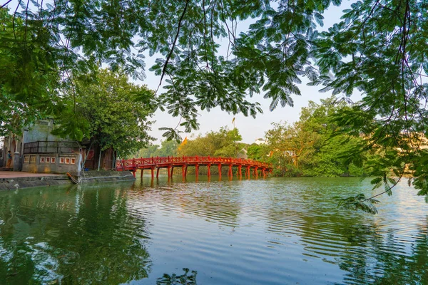 Le pont rouge dans le jardin du parc public avec des arbres et des reflets i — Photo