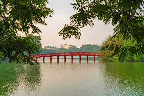 Le pont rouge dans le jardin du parc public avec des arbres et des reflets i — Photo