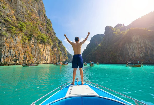 Asyalı bir adam, turist, şnorkelle yüzmek için teknede duruyor. — Stok fotoğraf