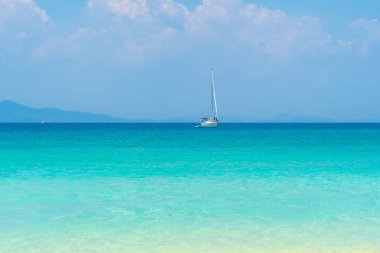 Phuket Adası yakınlarında mavi turkuaz deniz suyunda bir yelkenli.