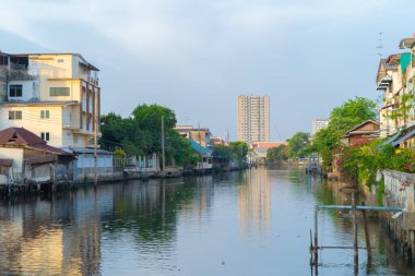 Asya 'daki kentsel kentte, Bangkok City, Tayland' da, Wutthakat ilçesi, doğa ağaçları olan Chao Phraya Nehri ve meskun evler. İkametgah evleri, öğleyin binalar..