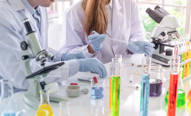 Laboratuvarda ya da laboratuarda teknoloji, kimya, sağlık, araştırma konsepti laboratuvarında covid-19 virüsünün aşısını analiz etmek ve geliştirmek için renkli test tüpleri üzerinde çalışan bilim adamları. Deneysel bilim testi