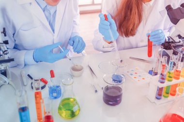 Laboratuvarda ya da laboratuarda teknoloji, kimya, sağlık, araştırma konsepti laboratuvarında covid-19 virüsünün aşısını analiz etmek ve geliştirmek için renkli test tüpleri üzerinde çalışan bilim adamları. Deneysel bilim testi