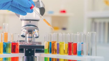 Laboratuvarda ya da laboratuarda teknoloji, kimya, sağlık, araştırma konsepti laboratuvarında covid-19 virüsünün aşısını analiz etmek ve geliştirmek için renkli test tüpleri üzerinde çalışan bilim adamları. Deneysel bilim testi